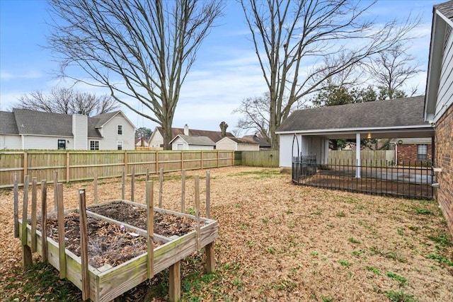 view of yard with a vegetable garden, a fenced backyard, and a residential view