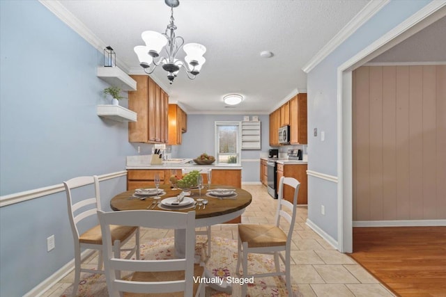 dining room with baseboards, a chandelier, ornamental molding, light wood-style floors, and a textured ceiling