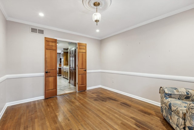 empty room with hardwood / wood-style flooring and crown molding