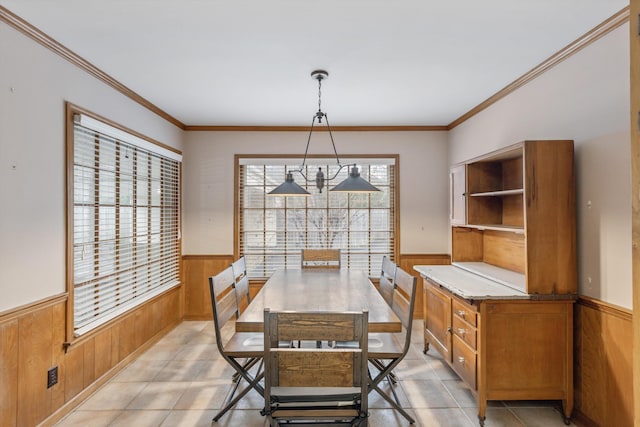 dining space featuring ornamental molding and wood walls