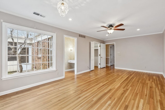 unfurnished bedroom with an inviting chandelier, crown molding, light hardwood / wood-style flooring, and ensuite bathroom