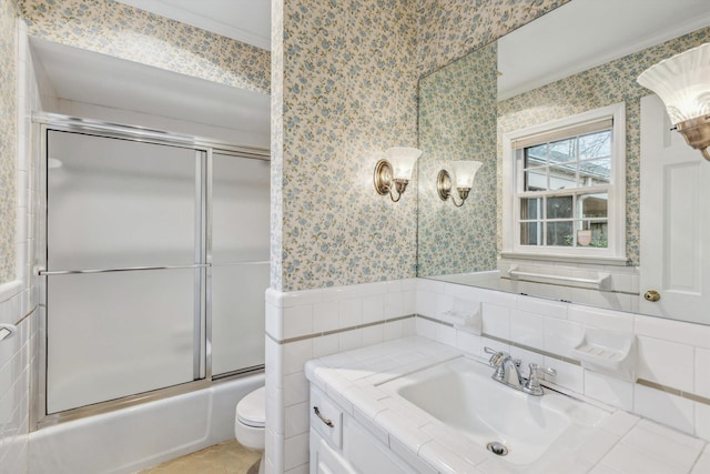 full bathroom with vanity, tile walls, shower / bath combination with glass door, and toilet