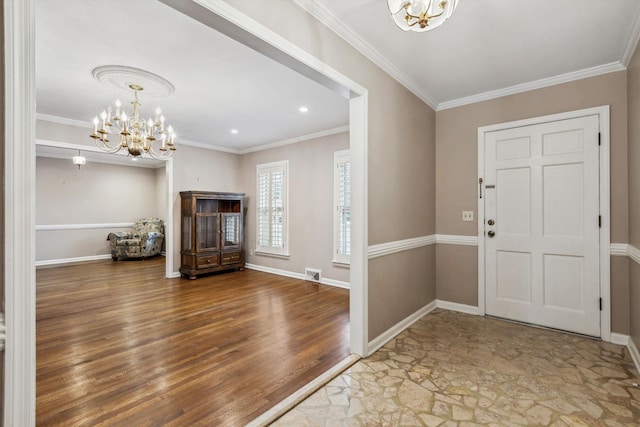 foyer entrance with hardwood / wood-style flooring, ornamental molding, and a chandelier