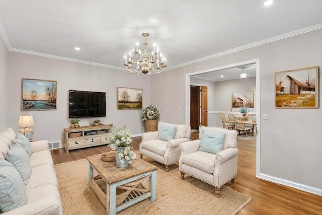 living room with crown molding, an inviting chandelier, and hardwood / wood-style floors