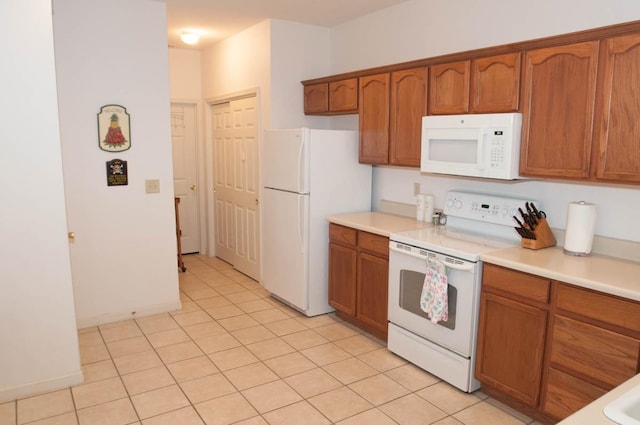 kitchen with light tile patterned flooring and white appliances