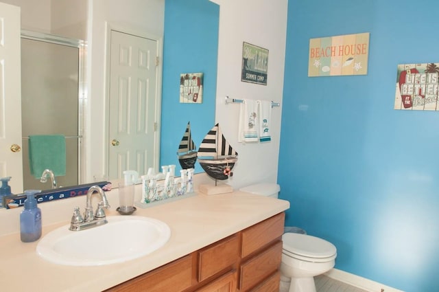 bathroom with a shower with door, vanity, and toilet