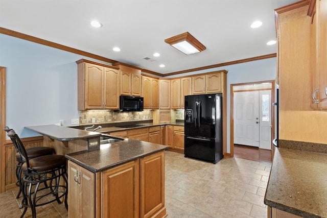 kitchen with crown molding, backsplash, a kitchen breakfast bar, black appliances, and kitchen peninsula