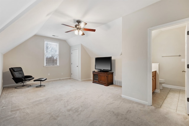 living area with vaulted ceiling, light colored carpet, and ceiling fan