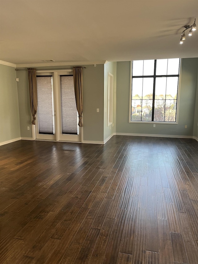 empty room featuring ornamental molding and dark hardwood / wood-style flooring