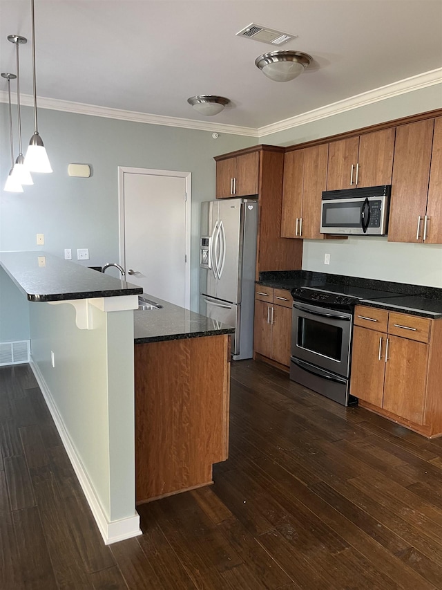 kitchen featuring stainless steel appliances, hanging light fixtures, sink, and dark hardwood / wood-style floors