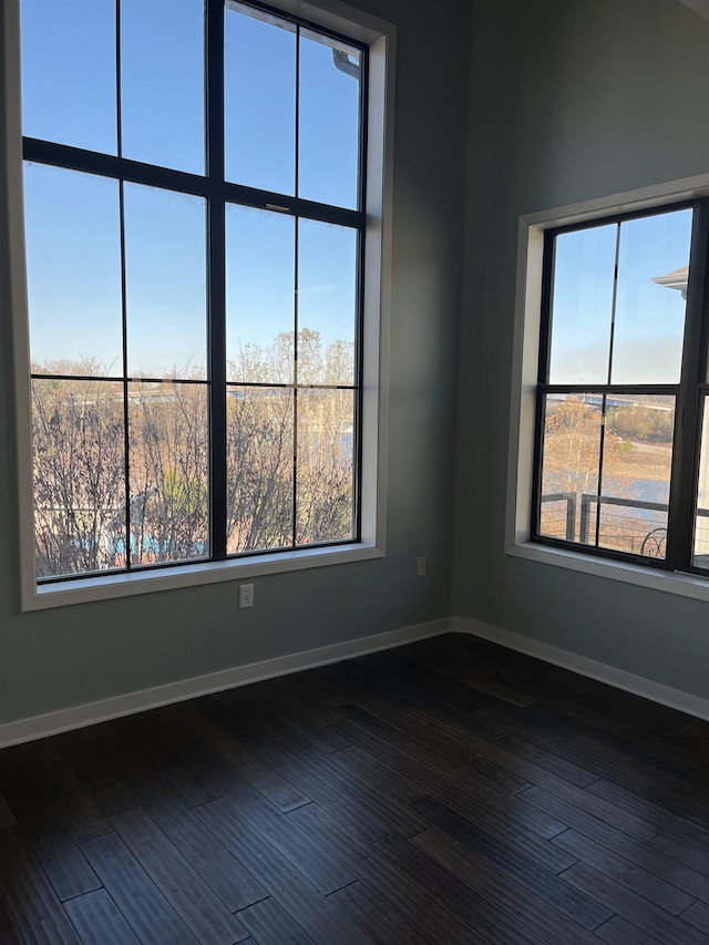 unfurnished room with dark wood-type flooring and a healthy amount of sunlight