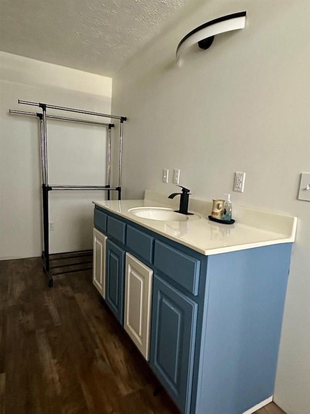 bathroom with vanity, wood-type flooring, and a textured ceiling