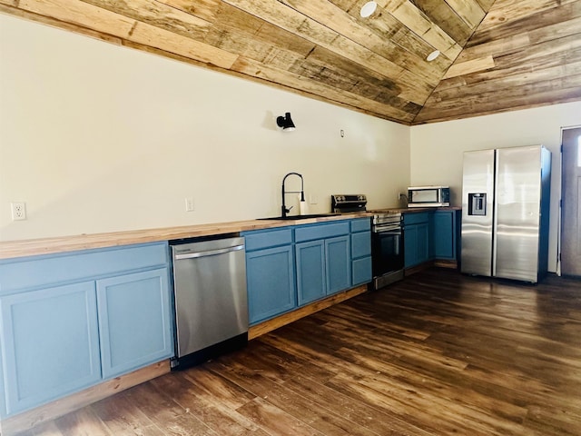 kitchen with appliances with stainless steel finishes, blue cabinets, sink, and butcher block countertops