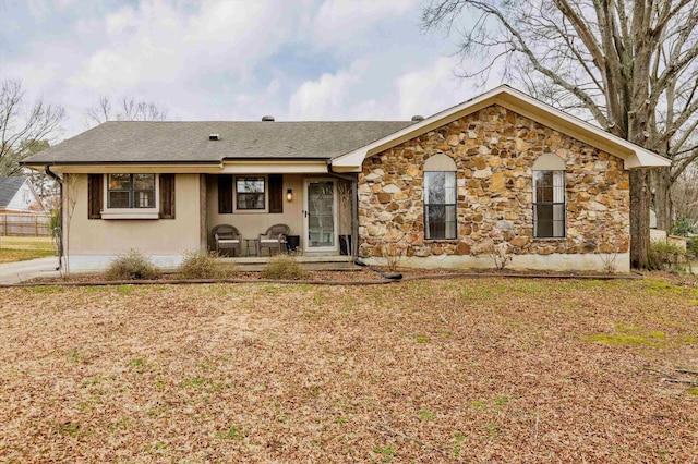 ranch-style home with a front yard and covered porch