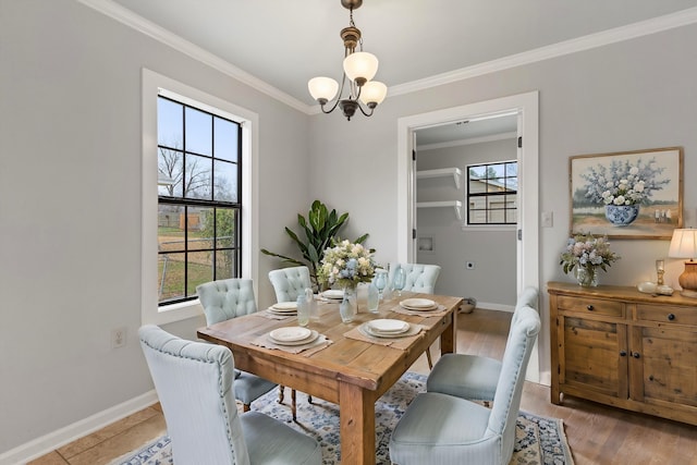 dining area with ornamental molding, light hardwood / wood-style floors, and a notable chandelier