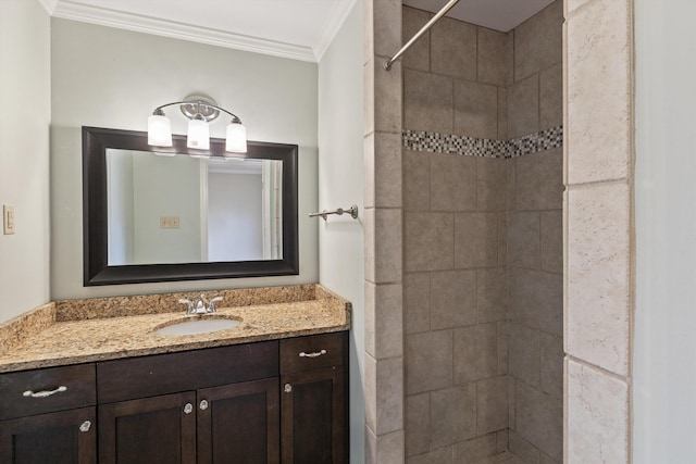 bathroom with ornamental molding, a tile shower, and vanity