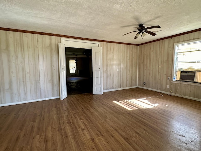 unfurnished bedroom featuring crown molding, ceiling fan, cooling unit, wood-type flooring, and a textured ceiling