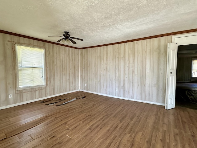 empty room featuring hardwood / wood-style flooring, ceiling fan, crown molding, and a textured ceiling