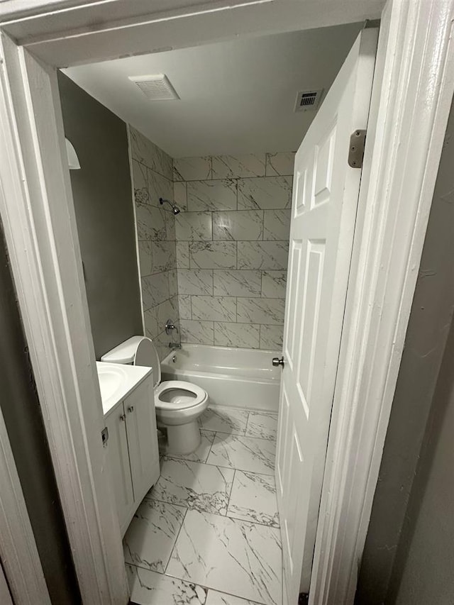 full bathroom featuring vanity, tiled shower / bath combo, and toilet