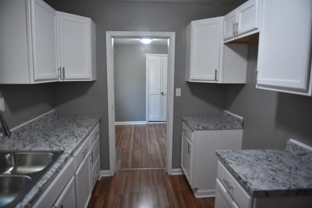 kitchen featuring white cabinetry, dark hardwood / wood-style floors, and light stone counters