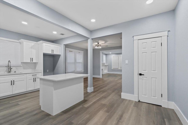 kitchen featuring white cabinetry, sink, dark hardwood / wood-style floors, and a center island