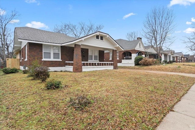 single story home with covered porch and a front yard