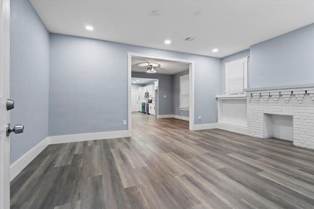 unfurnished living room with dark wood-type flooring and a fireplace