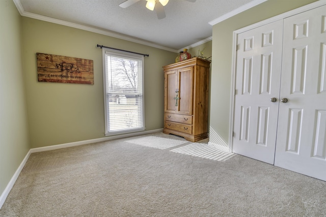 unfurnished bedroom featuring light carpet, ornamental molding, a closet, and a textured ceiling