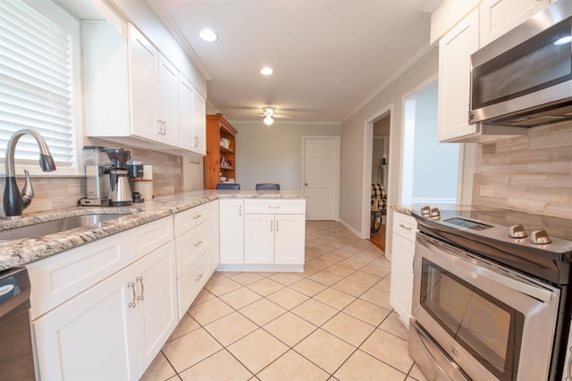 kitchen featuring sink, appliances with stainless steel finishes, ornamental molding, white cabinets, and kitchen peninsula