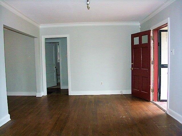 unfurnished room featuring dark hardwood / wood-style flooring and crown molding