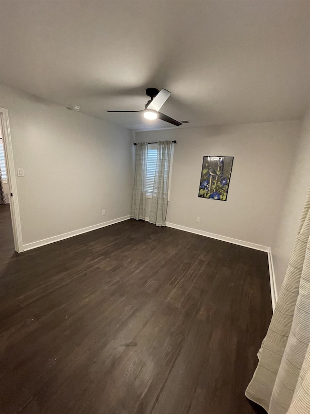 unfurnished room with dark wood-type flooring and ceiling fan