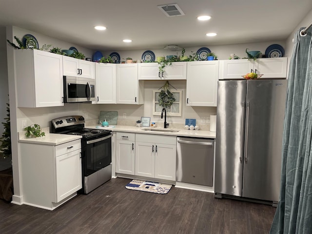 kitchen with white cabinetry, stainless steel appliances, dark wood-type flooring, and sink