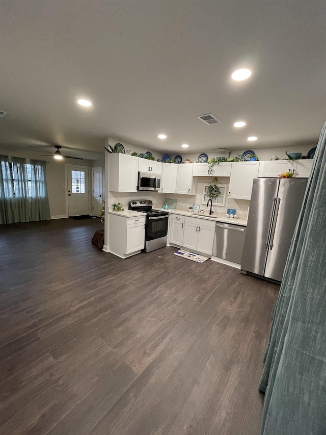 kitchen with sink, ceiling fan, appliances with stainless steel finishes, dark hardwood / wood-style floors, and white cabinets