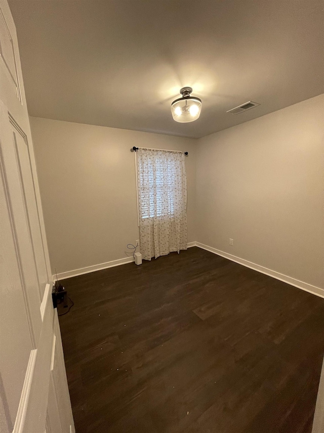 unfurnished room with dark wood-type flooring