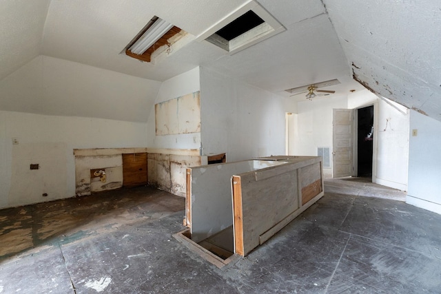 kitchen with light brown cabinetry and vaulted ceiling