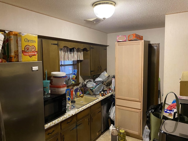 kitchen with appliances with stainless steel finishes, sink, dark brown cabinets, and a textured ceiling