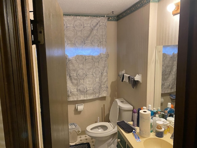 bathroom featuring vanity, toilet, and a textured ceiling