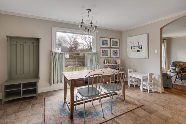 dining space with crown molding and an inviting chandelier