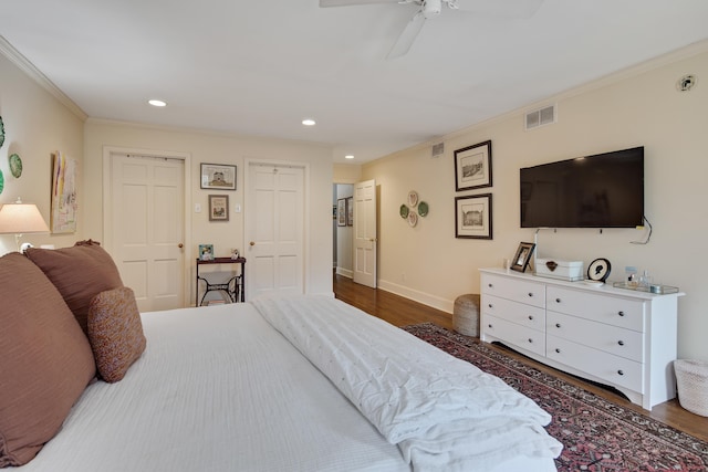 bedroom with crown molding, dark hardwood / wood-style floors, and ceiling fan