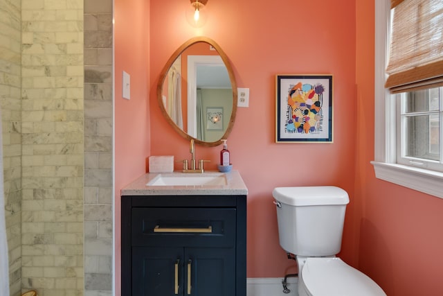 bathroom featuring vanity, toilet, and tiled shower