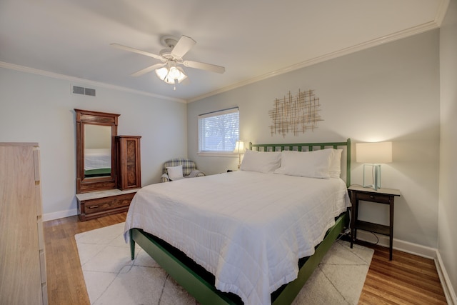 bedroom with ceiling fan, ornamental molding, and light hardwood / wood-style floors