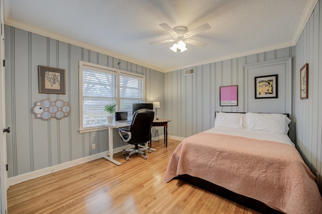 bedroom with crown molding, light hardwood / wood-style floors, ceiling fan, and a textured ceiling