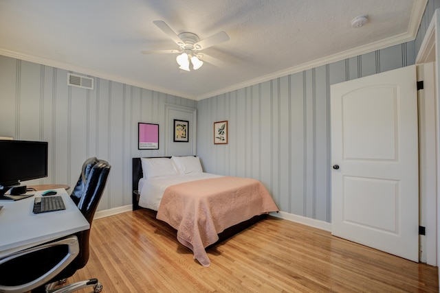 bedroom featuring a textured ceiling, ornamental molding, light hardwood / wood-style floors, and ceiling fan