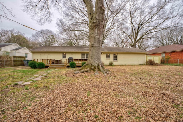 back of house with a lawn and a deck