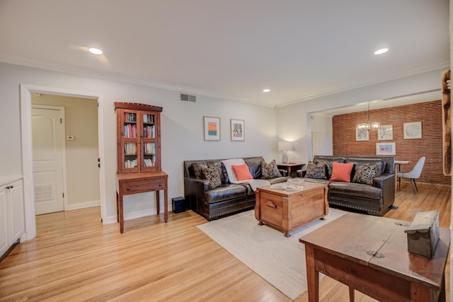 living room with an inviting chandelier, light hardwood / wood-style flooring, and ornamental molding