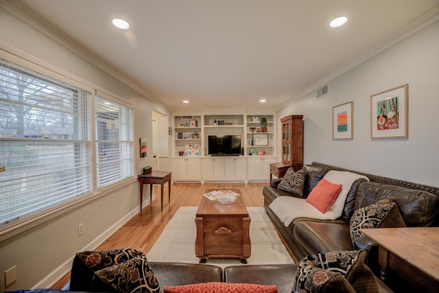 living room with crown molding, built in features, and light hardwood / wood-style flooring