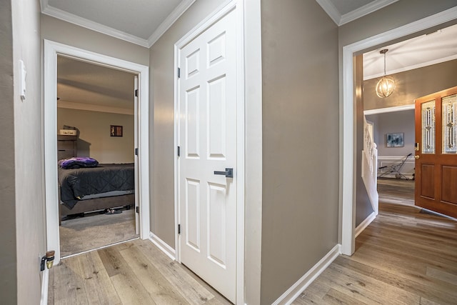 hall featuring crown molding and light hardwood / wood-style flooring