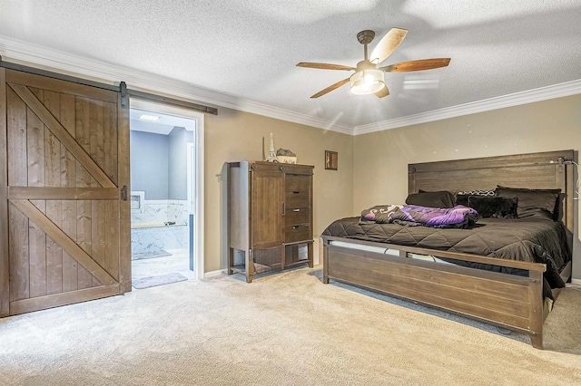 carpeted bedroom with ornamental molding, a barn door, a textured ceiling, and ensuite bath