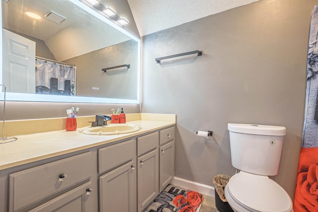 bathroom featuring vanity, lofted ceiling, a textured ceiling, and toilet