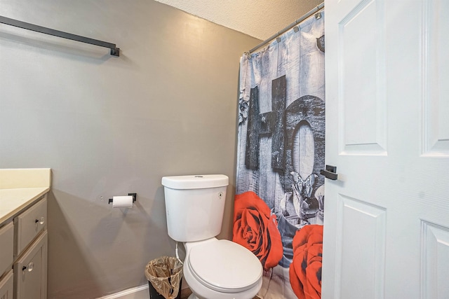 bathroom featuring vanity, a textured ceiling, and toilet